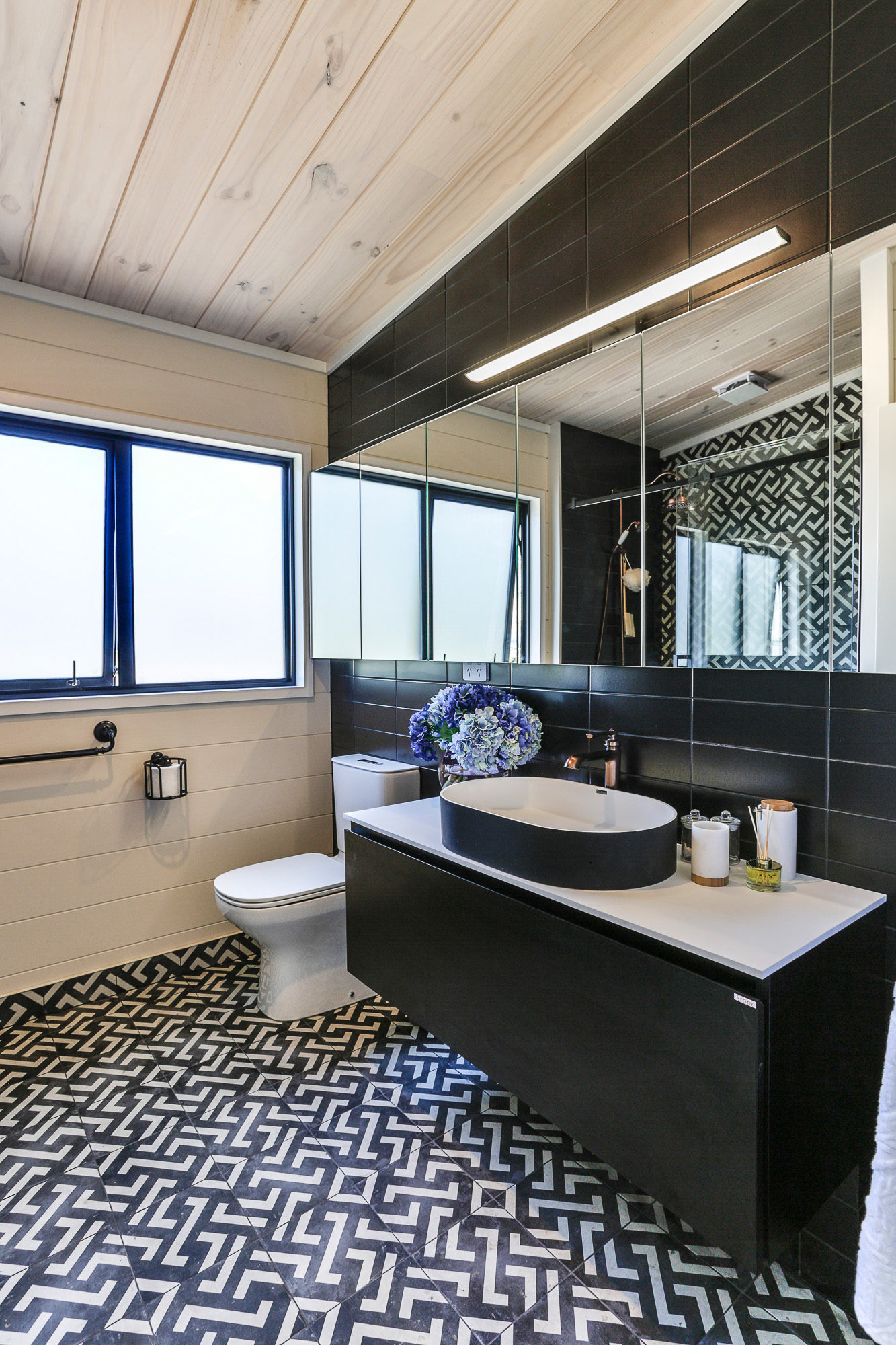 Modern Lockwood home bathroom with black subway tiles and cabinetry